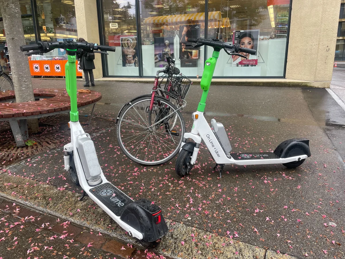 Zwei E-Trottinette der Marke Lime stehen am Strassenrand.